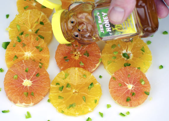 Drizzling Honey Over Oranges And Jalapeno